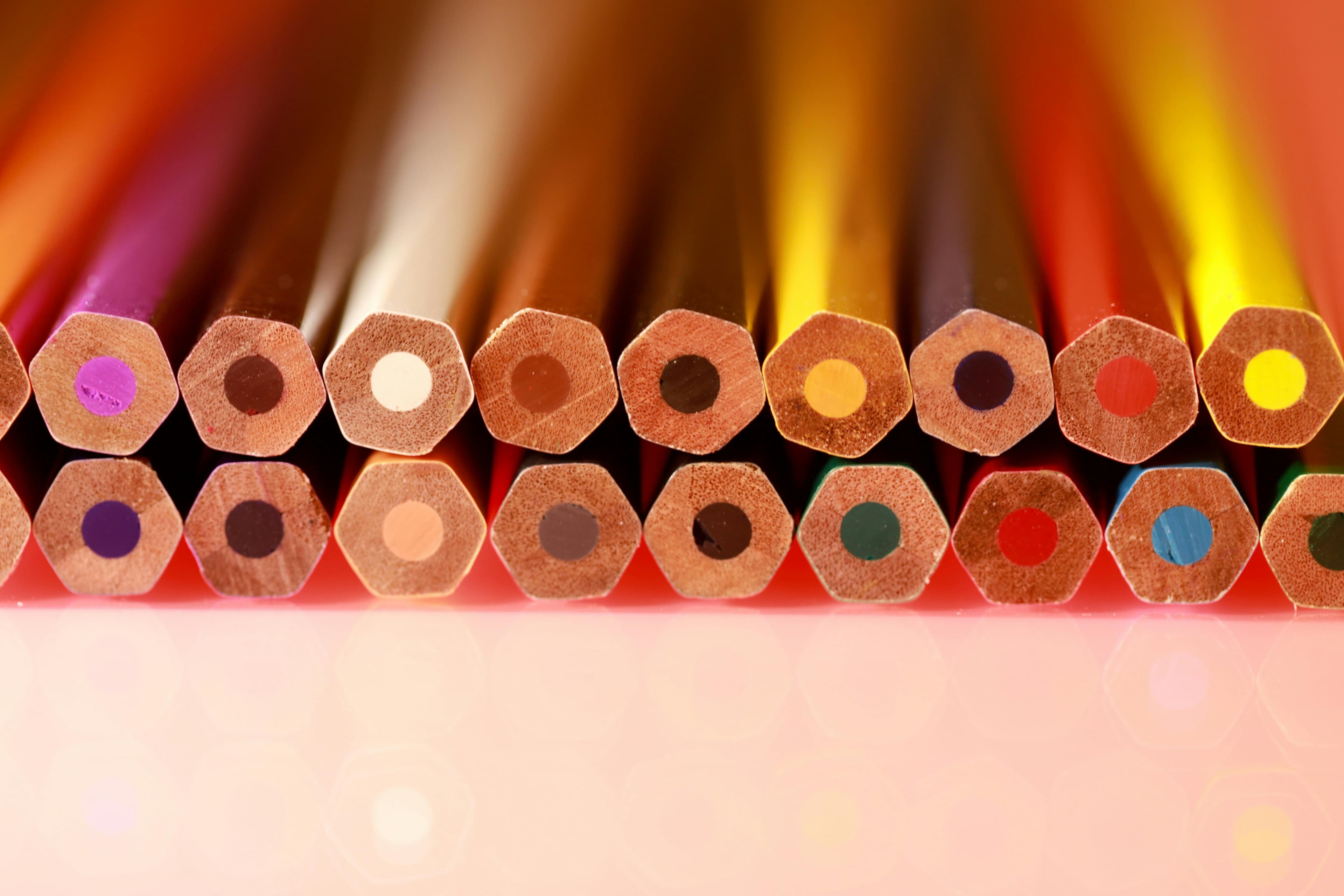 Close-up of chunky colored pencil and pastel ends in warm light