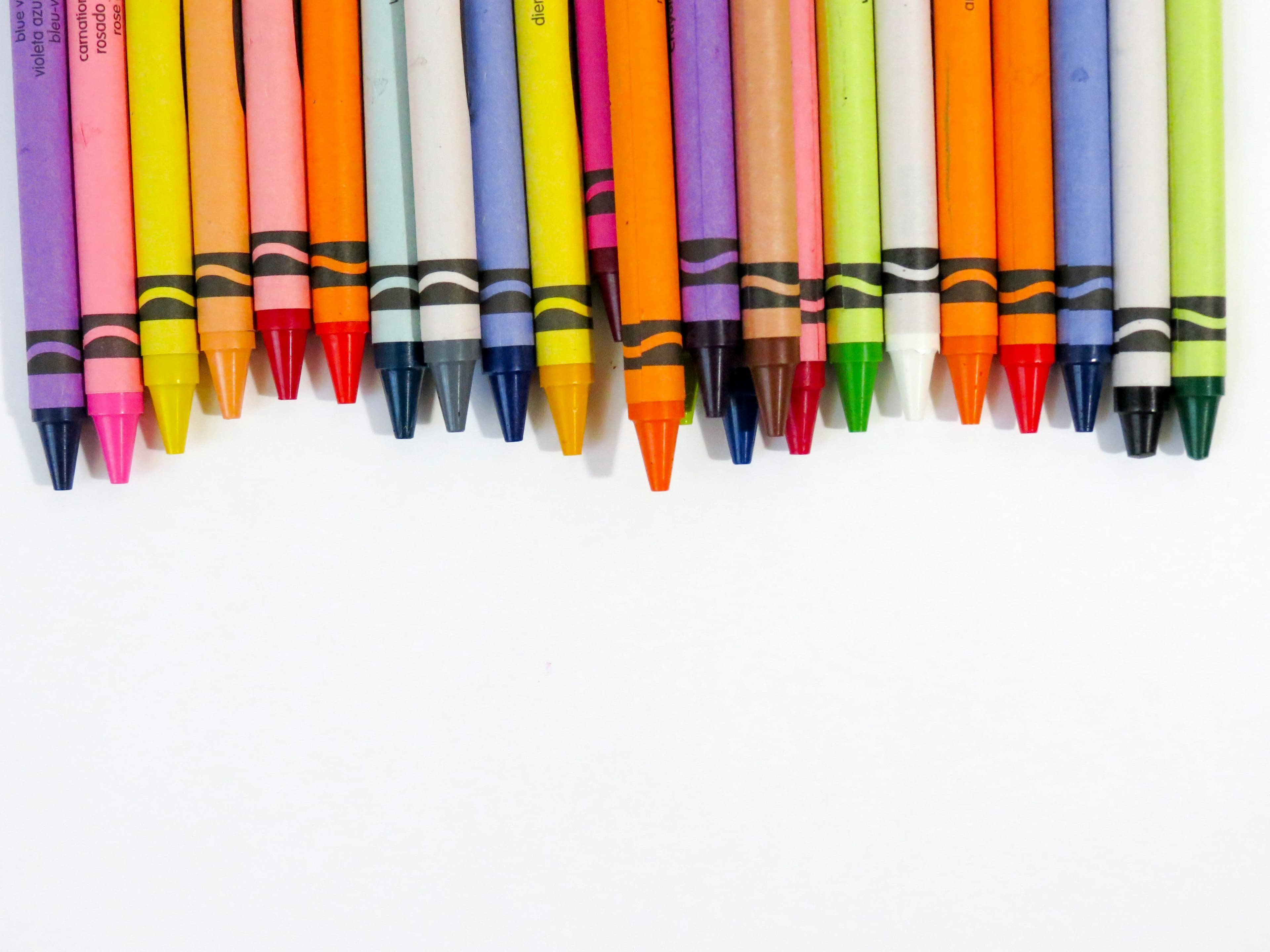 Row of colorful beeswax crayons with paper wrappers